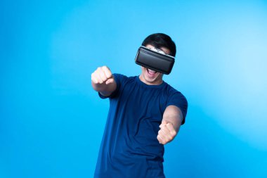 VR kullanan akıllı oyuncu, metaevrensel yeni dünyaya dönüyor. Araba yarışçısı, mavi arka planı izole ederek meta şehirde gelecekteki teknolojik sanal gerçekliğe bağlanıyor. Entrika.
