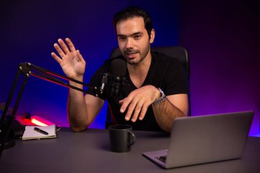 Yayıncı, fanclub dinleyicisiyle mikrofon kullanarak konuşuyor. Mor neon ışıklı modern stüdyoda yaratıcı olumlu düşünce konseptiyle canlı yayında finansal sorunları tartışıyor. Tahmin et..