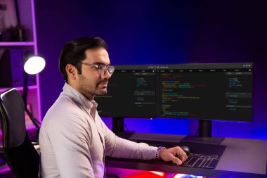 Bilgisayar ekranında çalışan akıllı bilişim geliştirici yazılım geliştirme kodlaması. Arka tarafa bakan, program güncellemesi düşünen, neon ışıklı siber ofis online web sitesi verileri. Tahmin et..