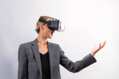 İş kadını, VR gözlük takıp beyaz arka planda dururken elinde bir şey tutuyor. Kulaklıklı proje yöneticisi görsel gerçeklik dünyasına teknolojik yenilikler kullanarak giriyor. Kısıtlanma.
