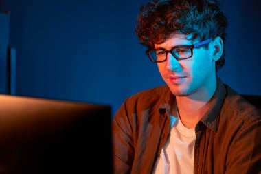 Genç işadamı, Neon Light Modern Ofis 'te yaratıcı bir başlangıç projesi için bilgisayara odaklanıyor. Düşünüyorum da, pazarlama ağı yaratıcıdan pazar kanalı tasarım konseptine çevrimiçi planlama. Toplayıcı.