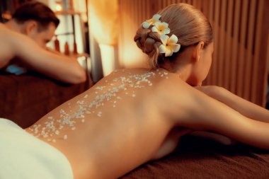 Lüks spa salonunda sıcak mum ışığı olan bir yerde deri dökülmesi tedavisi gören çift. Sağlık Spa vücut fırçasında tuz temizleme güzellik tedavisi. Sessiz.