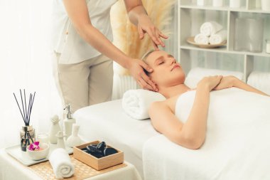 Kafkasyalı kadın stres önleyici kafa masajından ve lüks tatil beldesi ya da otel spa salonundaki modern ışık ortamında yüz güzelliği eğlencelerini şımartmaktan hoşlanıyor. Sessiz.