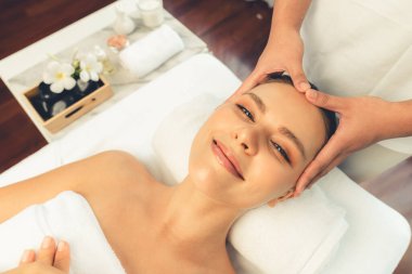 Kafkasyalı kadın stres önleyici kafa masajından ve lüks tatil beldesi ya da otel spa salonundaki modern ışık ortamında yüz güzelliği eğlencelerini şımartmaktan hoşlanıyor. Sessiz.