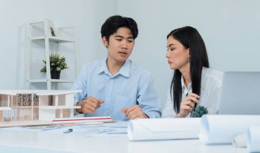 Kooperatif mühendis ekibinin portresi ev modelini ölçmek için cetvel ve mimari ekipmanlar kullanarak birlikte çalışıyor. Yaratıcı iş tasarımı ve takım çalışması konsepti. Tertemiz...