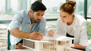 Kooperatif mimar mühendis ekibi kalem kullanarak ev modelini ölçmek için birlikte çalışıyor. Başarılı bir Kafkas iç mimari tasarım ekibi mimari model yapısını inceliyor. Tasarım. İzleme