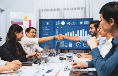 Analist ekip lideri, iş zekası ya da BI gösterge paneli ile FIntech yazılım gücünü kullanarak başarılı veri analizi toplantısından sonra iş arkadaşıyla tokalaştı. Tedbirli