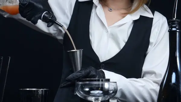 stock image Close up of smart bartender prepare cocktail with orange and rosemary at bar and modern pub. Professional bartender hands making a blood orange negroni with black background. Slow motion. Comestible.