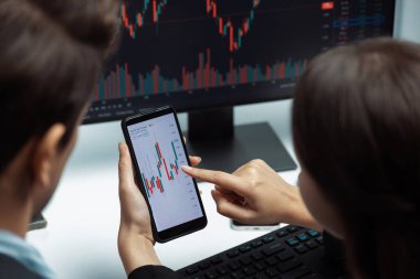 Telefona odaklanmak ve modern ofisteki gerçek zamanlı döviz kuru risk verileri üzerine ekranlarda dinamik borsa görüşmeleri yapmak. Varsayım.