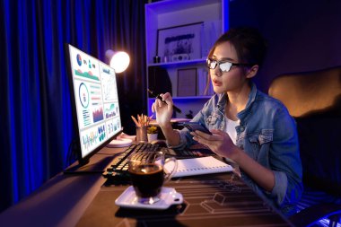 Sunucu kanalı Asyalı etkileyicisi, sosyal medyada kulaklık takarak iş grafikleri ekranında dinleyicileri selamlıyor ve Neon Modern Stüdyoları 'nda internet üzerinden koçluk yapıyor. Taktik.