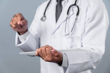 Tıbbi veri teşhisine işaret ederken, yetenekli doktorların ellerinin başvuru formunu tutması. Steteskop ve laboratuvar önlüğü giyen profesyonel bir doktor. Sapma.