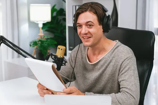 stock image Host channel in smart broadcaster with talking show on live social media streaming with script note reading to listeners, wearing headphones to record video streamer at modern home studio. Pecuniary.