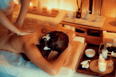 Beyaz kadın müşteri stres önleyici spa masajının keyfini çıkarıyor ve lüks otel ya da otelde sıcak mum ışığında güzellik teniyle eğleniyor. Sessiz.