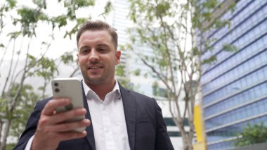 Düşük açılı kamera görüntüsü iş adamının telefonuna bakarken pazarlama ekibini arayıp Green City 'deki finansal plan hakkında fikir alışverişinde bulunması. Yönetici, iş arkadaşıyla telefonla konuşuyor. Urbane.