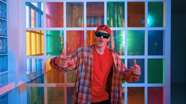 Komik break dansçı kameraya bakarken hiphop 'a doğru serbest adım atıyor. Çılgın mutlu hipster dans edip sokak dansı yaparken Led ışığında günlük kıyafet ve güneş gözlüğü takıyor. Mutluluk.