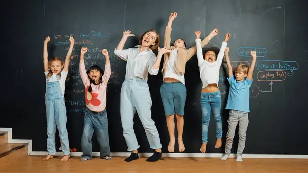 stock image Multicultural happy student and teacher smiling and standing at blackboard with engineering code or prompt written. Kid express feeling of happy and enjoy with studying in STEM classroom. Erudition.