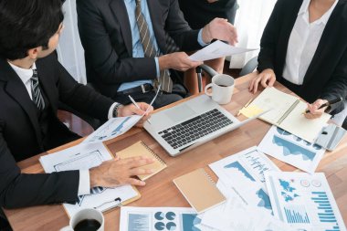 Ofis masasındaki finansal veri raporlarını analiz eden çeşitli bir grup iş analisti. Stratejik pazarlama planlaması için iş istihbarat analizine göre grafikler ve grafikler.