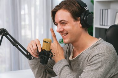 Sunucu kanalı, gülümseyen akıllı yayıncı kaydı, senaryosu ve akıllı telefonuyla sosyal medyada sohbet programı, kulaklık takarak modern ev stüdyosundaki video flamalarını kaydediyor. Bireysel.