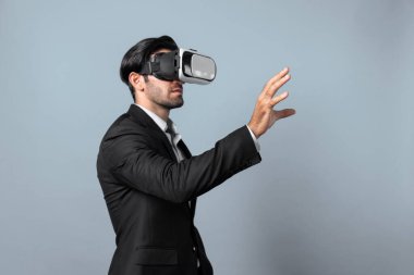 Profesyonel, zeki iş adamı, VR gözlük takarken elinde bir şey tutuyor. Sanal gerçeklik gözlüklü Kafkas proje yöneticisi mavi arka planlı mevcut teknoloji yeniliği. Sapma.
