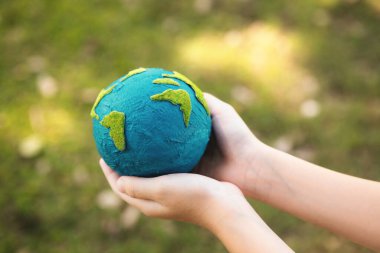 Dünya gezegenini ESG ilkesi ve çevre dostu enerjisiyle daha parlak bir gelecek için Dünya günü olarak el ele tutuşan genç çocuklar. Döngü