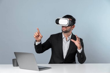Bilgisayarla masada otururken ve VR gözlüğü takarken veri analizine bakan yetenekli bir iş adamı. Proje yöneticisi sanal gerçeklik sistemini kullanarak ya da metaevrende bağlantı kurarak çalışıyor. Sapma.
