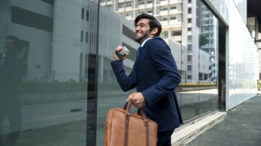 Cam duvarda yürürken neşeyle dans eden yetenekli bir iş adamı. Proje müdürü iyi haberler aldı, terfi aldı, başarılı bir iş buldu, aynı zamanda coşkuyu dile getirdi. Sevinçli..