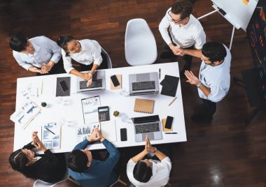 Üst düzey ofis çalışanları stratejik iş pazarlama toplantısı üzerine anlaşma yaptıktan sonra el sıkışıyor. Takım çalışması ve olumlu tutum verimli ve destekleyici bir iş yeri yaratır. Tedbirli