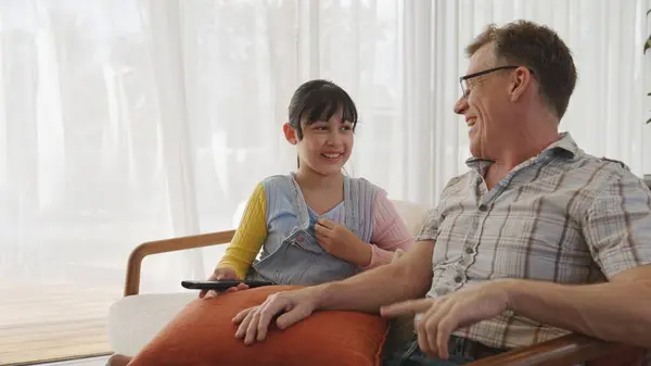 stock image Grandfather and granddaughter together watch interesting entertainment media on TV. Old senior use technology communicate with young generation cross generation gap strengthen family bond. Divergence.