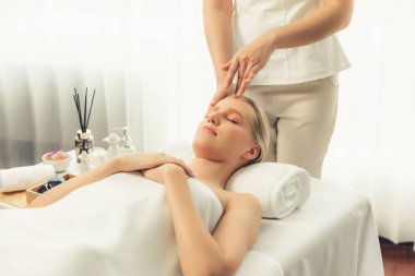 Kafkasyalı kadın stres önleyici kafa masajından ve lüks tatil beldesi ya da otel spa salonundaki modern ışık ortamında yüz güzelliği eğlencelerini şımartmaktan hoşlanıyor. Sessiz.