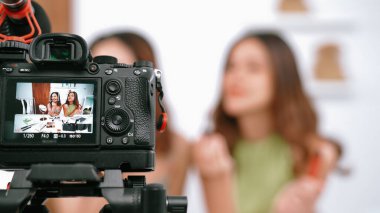 Etkilenen iki ortak canlı yayın yapan video görüntülerini sosyal medya ya da blog üzerinden gözden geçirir. Canlı kozmetik stüdyosu ışıklandırması olan mutlu genç bir kız pazarlama için internet üzerinden yayın yapıyor..