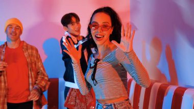 Çok kültürlü bir arkadaş birlikte dans ediyor ve hiphop müziği eşliğinde restoranda ya da kafede pembe neon ışıklı duruyor. Profesyonel sokak dansçıları grubu enerjik hareketler sergiliyor. Mutluluk.