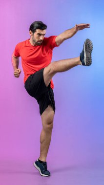 Vücut uzunluğunun tamamı atletik ve sporcu genç bir adamın kardiyo egzersizinde, izole edilmiş arka planda tekme pozisyonunda. Sağlıklı aktif ve vücut bakımı yaşam tarzı.
