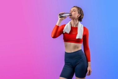 Vücut uzunluğunun tamamı atletik ve sportif genç bir kadını havluyla ve içme suyuyla izole edilmiş arka planda egzersiz yaparken çekilir. Sağlıklı aktif ve vücut bakımı yaşam tarzı.