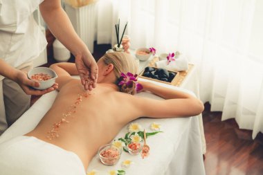 Lüks spa salonlarında sıcak mum ışığında cilt bakımı yaptıran kadın müşteri. Sağlık Spa vücut fırçasında tuz temizleme güzellik tedavisi. Sessiz.