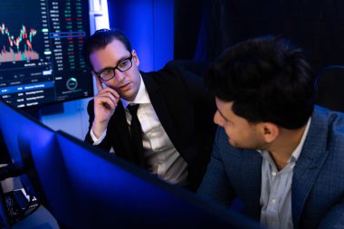 Dinamik veri monitörüne odaklanan iki borsa simsarı dijital para birimi veya piyasayı tartışıyor. Neon-light dekoratif işyerindeki pazar hisselerini analiz etme kavramı. Satılabilir.