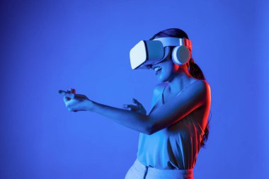VR kulaklık takan zeki bir kadın metaevrene bağlanıyor, gelecekteki siber uzay topluluğu teknolojisi. Sanal silaha hükmeden zarif bir kadın ciddi ciddi oyun oynuyor. Halüsinasyon.