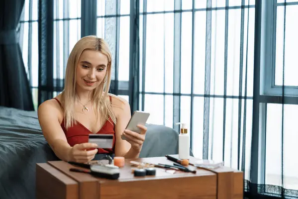 stock image Young woman using online payment app and digital wallet on smartphone to pay with credit card. E commerce shopping and modern purchasing via mobile internet. Blithe