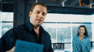 Profesyonel iş adamları yaratıcı pazarlama fikrini modern ofiste tartışırlar. İş adamları cam tahtada yapışkan notlar kullanarak finansal plan üzerinde çalışıyor. Yönlendirici.