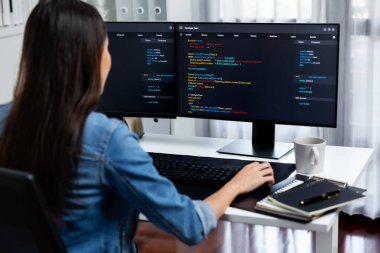 İnternet sitesi uygulamasının kodlama verileriyle birlikte online bilgi yazarak kot gömlek giyen genç Asyalı geliştirici. Güvenlik analizi ile çevrili iki ekran. Taktik.