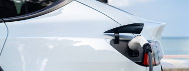 Açık hava EV şarj istasyonundaki elektrikli araba şarj istasyonu ya da deniz manzaralı araba, çevre dostu araba için alternatif ve sürdürülebilir enerji teknolojisi. Panorama Daimi