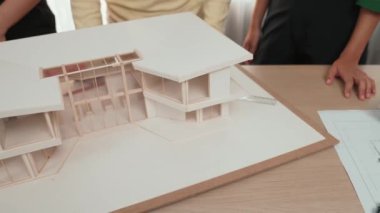Mimari ekipman kullanarak yavaş çekim ev tasarımcısı bir plan çizerken, iç mimari tasarımcı da müşterilerin talebine göre renk örneklerinden uygun renkler seçiyor. Değiştirilmiş