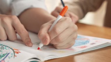 Değişik öğrenci el çizimleri ve boyamalarının resimlerini çizim kitabında işaretleyici kullanarak çektik. Sanat dersinde çizim kitabını kullanan çok kültürlü öğrencilerin yakın çekimi. Rahatlama. Etkinlik.