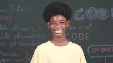 Makineye gülümseyen Afrikalı bir yetişkin. Mühendislik koduyla ya da dakik bir şekilde tahtada dururken. BTMM Teknoloji dersine katılırken günlük kıyafet giyen yakışıklı bir genç. Öğretim