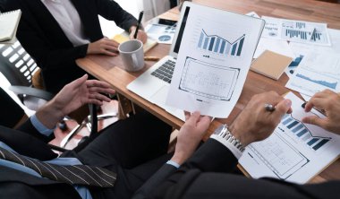 Ofis masasındaki finansal veri raporlarını analiz eden çeşitli bir grup iş analisti. Stratejik pazarlama planlaması için iş istihbarat analizine göre grafikler ve grafikler.