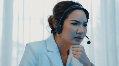 İş kadını kulaklık takıyor ve uzaktan müşteri ya da iş arkadaşını desteklemek için ofiste çalışıyor. Hüsrana uğramış ve yorgun çağrı merkezi müşteri destek aracısı Vivancy hizmeti sağlamada sorunla karşı karşıya