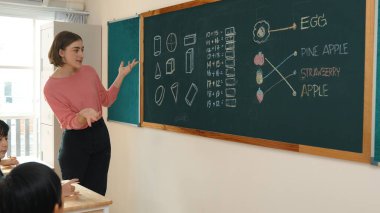 Zeki öğretmen sınıfta fikri açıklarken sevimli öğrenci ödevlerini kontrol ediyor. Not defterine bakıp matematik teorisinden çocuğa bahsederken sınıfta dolaşan çekici bir eğitmen. Pedagoji.