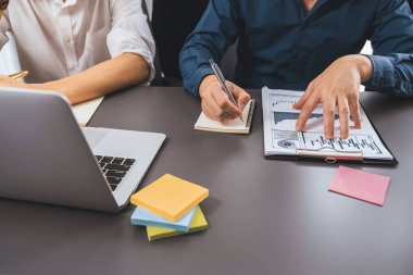 Çeşitli ofis çalışanlarından oluşan bir grup, ofis çalışma alanına yapışkan bir notla stratejik iş pazarlama planlaması üzerine beyin fırtınası yapıyor. İş yerinde olumlu ve verimli bir takım çalışması. Tedbirli.