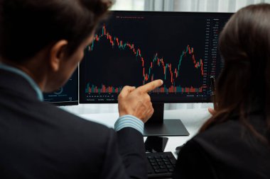 Dinamik borsada döviz kuru yatırımını tartışan iki ticaret simsarı iki bilgisayar ekranında gerçek zamanlı risk grafiği ya da modern ofisteki kar noktasını karşılaştırıyor. Varsayım.