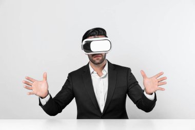 Akıllı iş adamı teknoloji yeniliklerini kullanarak veri analizini işaret ederek ve seçerek oturuyor. Sanal gerçeklik gözlüğü ve sanal gerçeklik gözlüğü kullanan profesyonel Kafkas proje yöneticisi. Sapma.