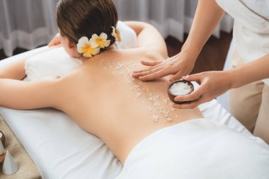 Lüks spa salonlarında sıcak mum ışığında cilt bakımı yaptıran kadın müşteri. Sağlık Spa vücut fırçasında tuz temizleme güzellik tedavisi. Sessiz.